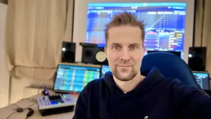 Enrico Wachtel im Studio, im Hintergrund Bildschirme und Studiolautsprecher